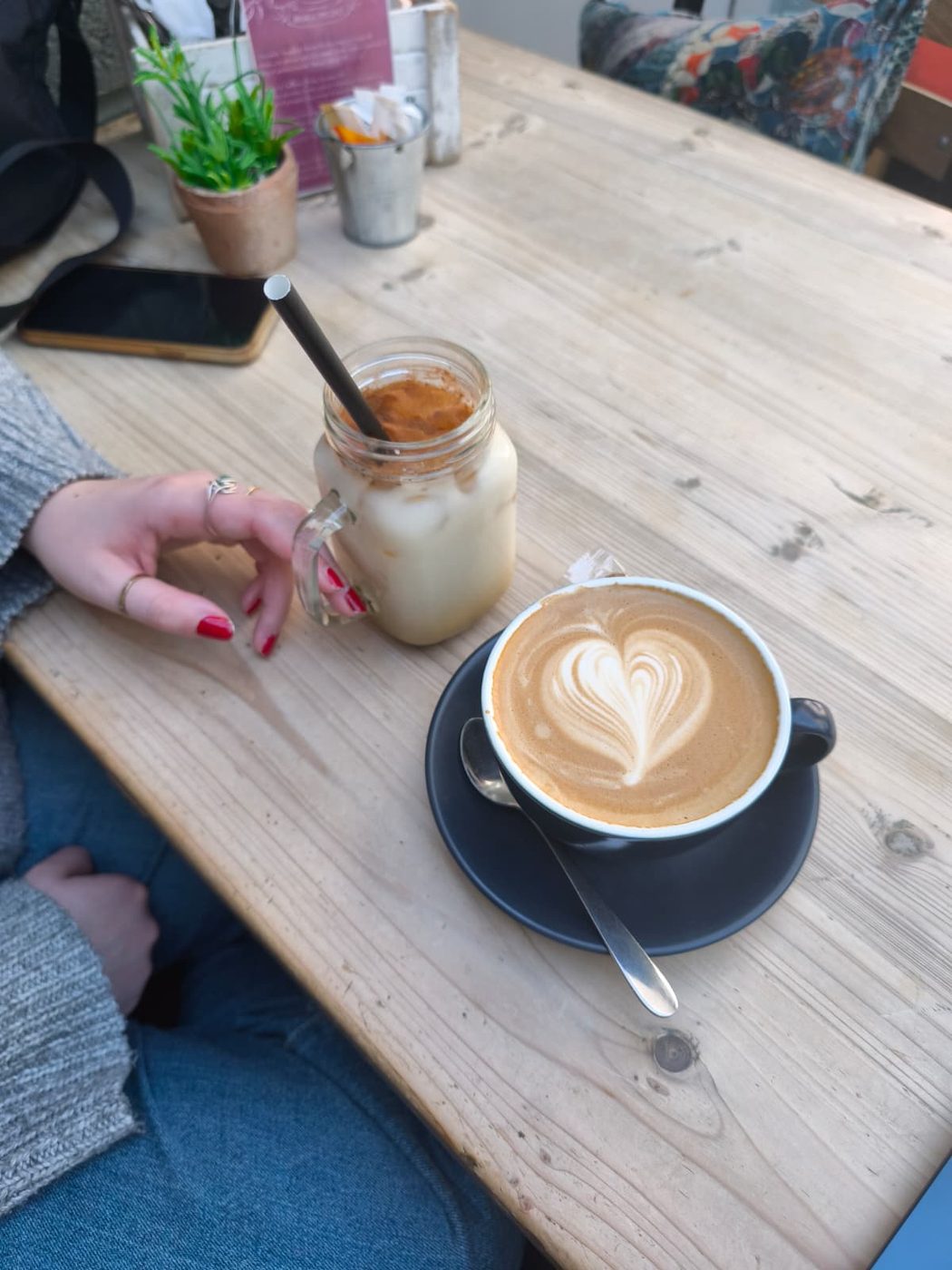 An iced coffee and a latte on a cafe table