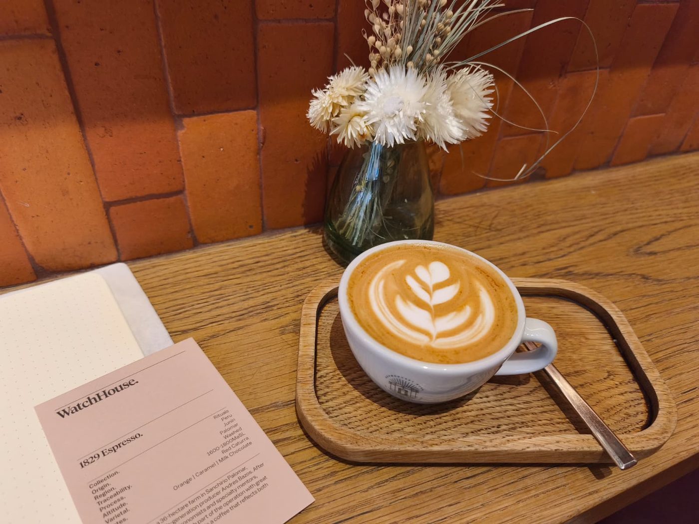 A flat white with latte art on a cafe counter